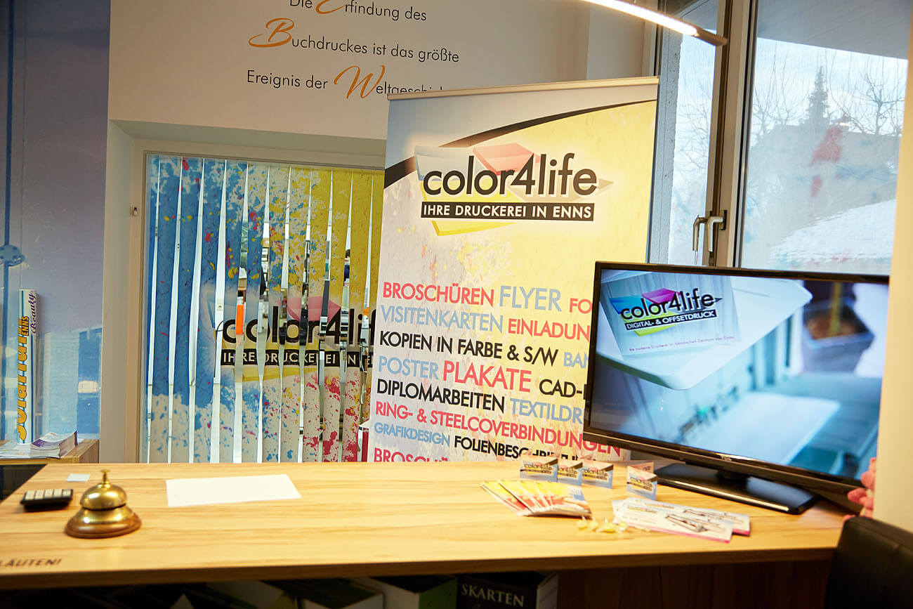 Im Eingangsbereich der color4life steht ein Rollup mit allen Produkten und ein Imagevideo unserer Produktionshallen wird vorgeführt
