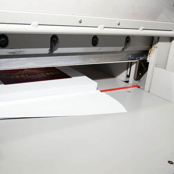 An der Schneidemaschine werden die Druckbögen in das richtige Format geschnitten